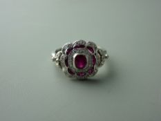 A FOURTEEN CARAT WHITE GOLD RUBY & DIAMOND FANCY CLUSTER DRESS RING having a centre oval ruby with