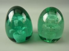 TWO VICTORIAN GREEN GLASS DUMP PAPERWEIGHTS with multiple head floral in pot inclusions, 12 cms high