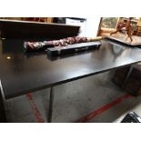 A large black retro dining table on chrome legs