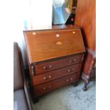 An Edwardian inlaid mahogany three-drawer sloped front bureau