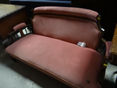 An inlaid Edwardian settee upholstered in pink dralon fabric