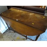 An antique gate leg barley-twist dining table with end drawer