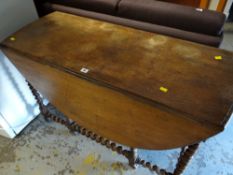 An antique gate leg barley-twist dining table with end drawer