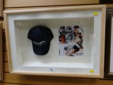 A Mickey Mantle merchandise baseball cap in a frame with pictorial statistics for the player