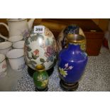 Two decorative porcelain eggs on stands and modern cloisonne