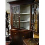 An antique oak standing corner cabinet with two-door cupboard base with astragal glazed two-door