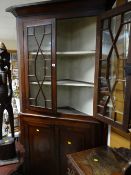 An antique oak standing corner cabinet with two-door cupboard base with astragal glazed two-door