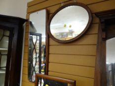 A small mahogany framed oval wall mirror together with a modern hall mirror