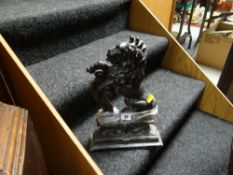 A painted black cast metal door stop in the form of a rearing lion