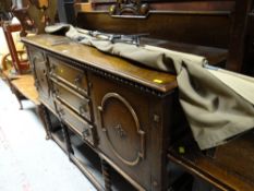 A good mid-twentieth century oak railback sideboard with three-drawers, flanked by two cupboards