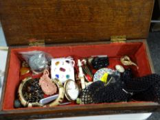 A heavily carved wooden sewing box with costume jewellery contents