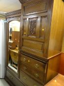 An Edwardian compact oak mirror doored wardrobe with carved decoration & a bank of drawers with