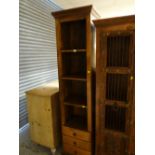 A modern hardwood tall narrow open shelving unit with three drawers to the base