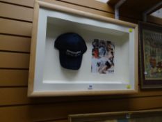 A Mickey Mantle merchandise baseball cap in a frame with pictorial statistics for the player