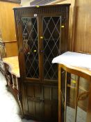 A vintage Old Charm-style dark oak standing corner cupboard with two-door cupboard base & leaded