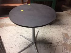 A small black ash circular table with chrome legs