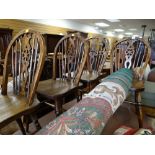 A set of four dark stained wheel back kitchen chairs
