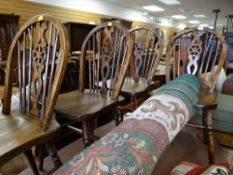 A set of four dark stained wheel back kitchen chairs