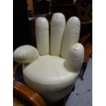 An unusual small hand shaped rotating chair in cream leather covering