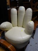 An unusual small hand shaped rotating chair in cream leather covering