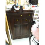 An antique oak hanging corner cupboard with three-shelf interior & small drawer to base (