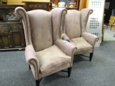A pair of Andrew Martin 'Winston' armchair in the wing back-style with buttoned 'moccasin'