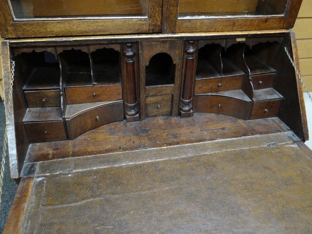 AN EARLY NINETEENTH CENTURY OAK BUREAU BOOKCASE having a two door glazed top with sloped front - Image 3 of 3