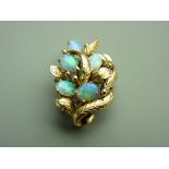 A FOURTEEN CARAT GOLD LEAF & FLORAL FOIL BACKED BROOCH having five oval cabochon opals, 6.7gms gross