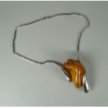 A POLISH SILVER & AMBER PENDANT the silver marked k800 with head profile looking right, on a
