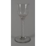 A MID-EIGHTEENTH CENTURY OPAQUE TWIST STEM DRINKING GLASS having a fluted funnel shaped bowl over