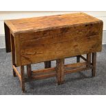 A NINETEENTH CENTURY JOINED OAK GATE LEG TABLE, the base with twin 'gates' at either side