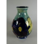 A MOORCROFT LIGHT & DEEP BLUE GROUND TUBE-LINED FLORAL VASE of baluster form with narrow slightly