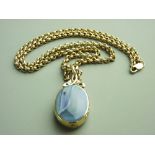 A NINE CARAT GOLD AGATE & BLUE GOLDSTONE OVAL PENDANT in an attractive mount and having a 60cms
