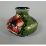 A MOORCROFT GREEN GROUND SQUAT NARROW NECKED VASE with tube-lined flowers, 7cms high