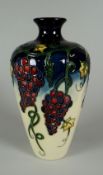 A 2009 MOORCROFT BALUSTER VASE in the Grapevine pattern, 16cms high