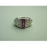 A FOURTEEN CARAT WHITE GOLD PINK SAPPHIRE & DIAMOND DRESS RING, the oblong emerald cut faceted