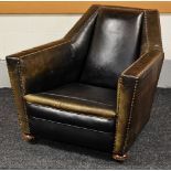 AN UNUSUAL STUDDED LEATHER ANTIQUE ARMCHAIR on bun feet with castors