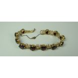 A 9CT YELLOW GOLD SET RED GARNET BRACELET of floral design, 17gms