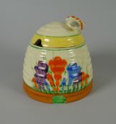 A CLARICE CLIFF POTTERY BEEHIVE HONEY POT with floral decoration & insect handle, 9cms high