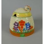 A CLARICE CLIFF POTTERY BEEHIVE HONEY POT with floral decoration & insect handle, 9cms high