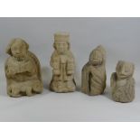 FOUR UNUSUAL SANDSTONE FIGURES one being a religious figure reading, another with two bags of money,