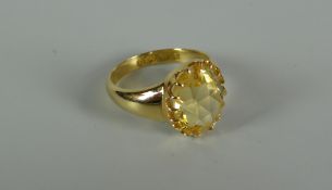 AN 18CT GOLD & YELLOW STONE RING probably citrine in a raised multi-claw setting, plain tapering