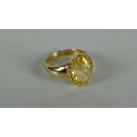 AN 18CT GOLD & YELLOW STONE RING probably citrine in a raised multi-claw setting, plain tapering