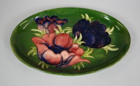 A MOORCROFT OVAL GREEN GROUND DISH with tube-lined flowers, 23cms