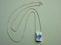 AN EIGHTEEN CARAT WHITE GOLD GRADUATED SATURATION TANZANITE PENDANT WITH CHAIN, the tanzanites