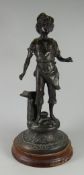 A BRONZE FIGURE OF A BLACKSMITH'S BOY standing aside an anvil on a circular base and wooden mount,