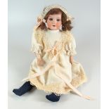 AN ARMAND MARSEILLE BISQUE HEAD DOLL with open eyes, open mouth with upper teeth and with wig,