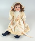 AN ARMAND MARSEILLE BISQUE HEAD DOLL with open eyes, open mouth with upper teeth and with wig,
