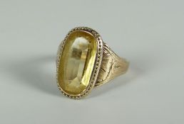 A VICTORIAN GOLD & CITRINE RING the stone in a relief decorated border and with engraved