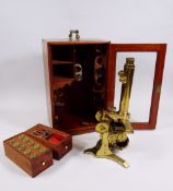 AN ANTIQUE BRASS BINOCULAR MICROSCOPE BY J H STEWARD with two rise & fall adjusters, two adjusters
